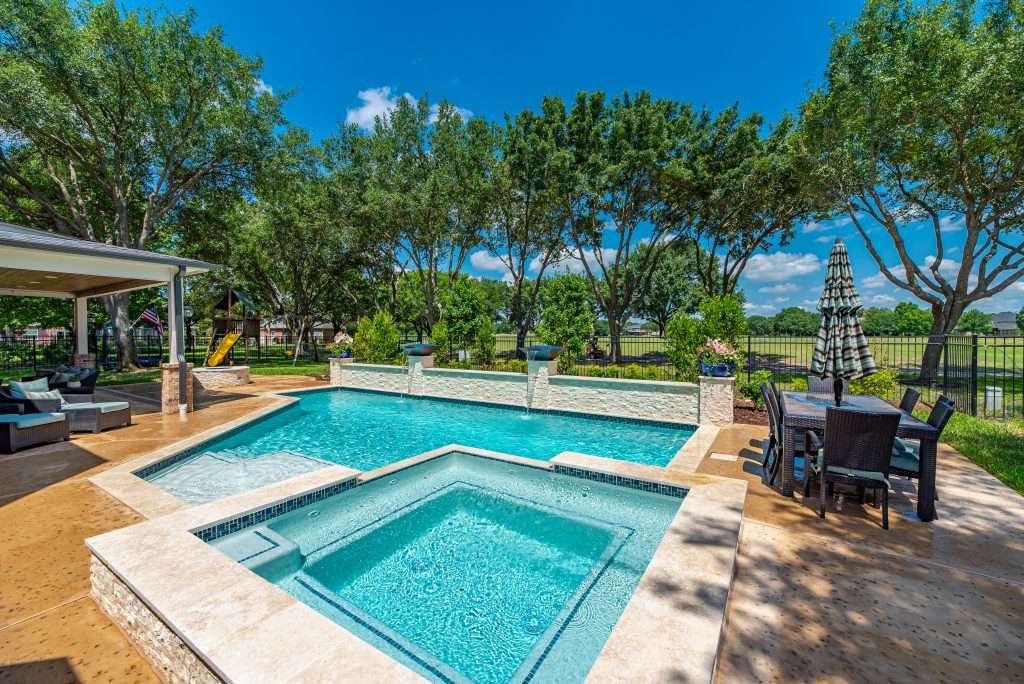 A serene backyard oasis featuring a pool and comfortable patio furniture for relaxation and outdoor gatherings.